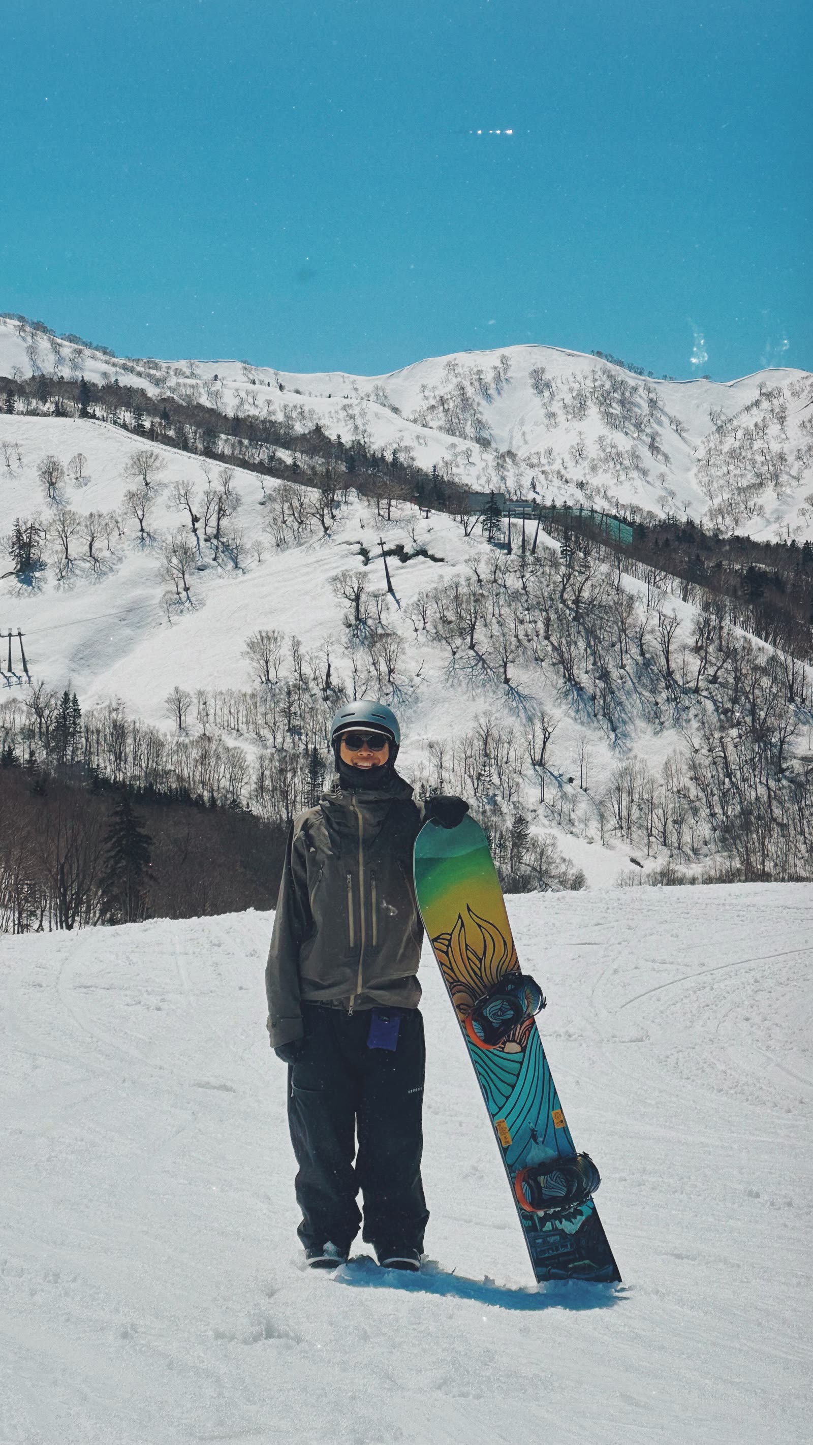 匠滑雪教練 RK 在晴天雪道上與單板雪板合影