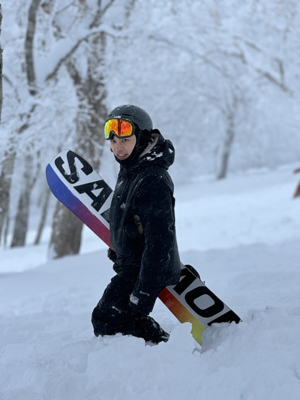 匠滑雪教練 Stanley 在雪場林間手持單板雪板