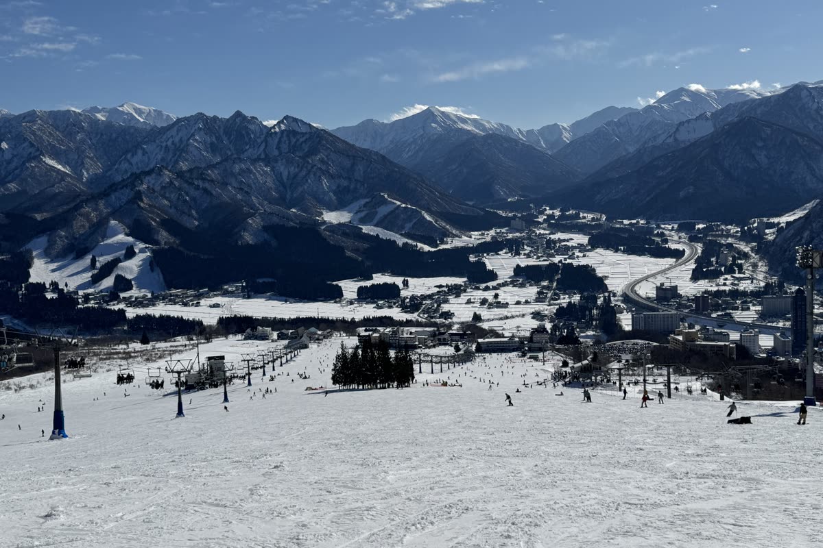 晴天下的岩原雪道，纜車站與遠方城鎮、山脈盡收眼底