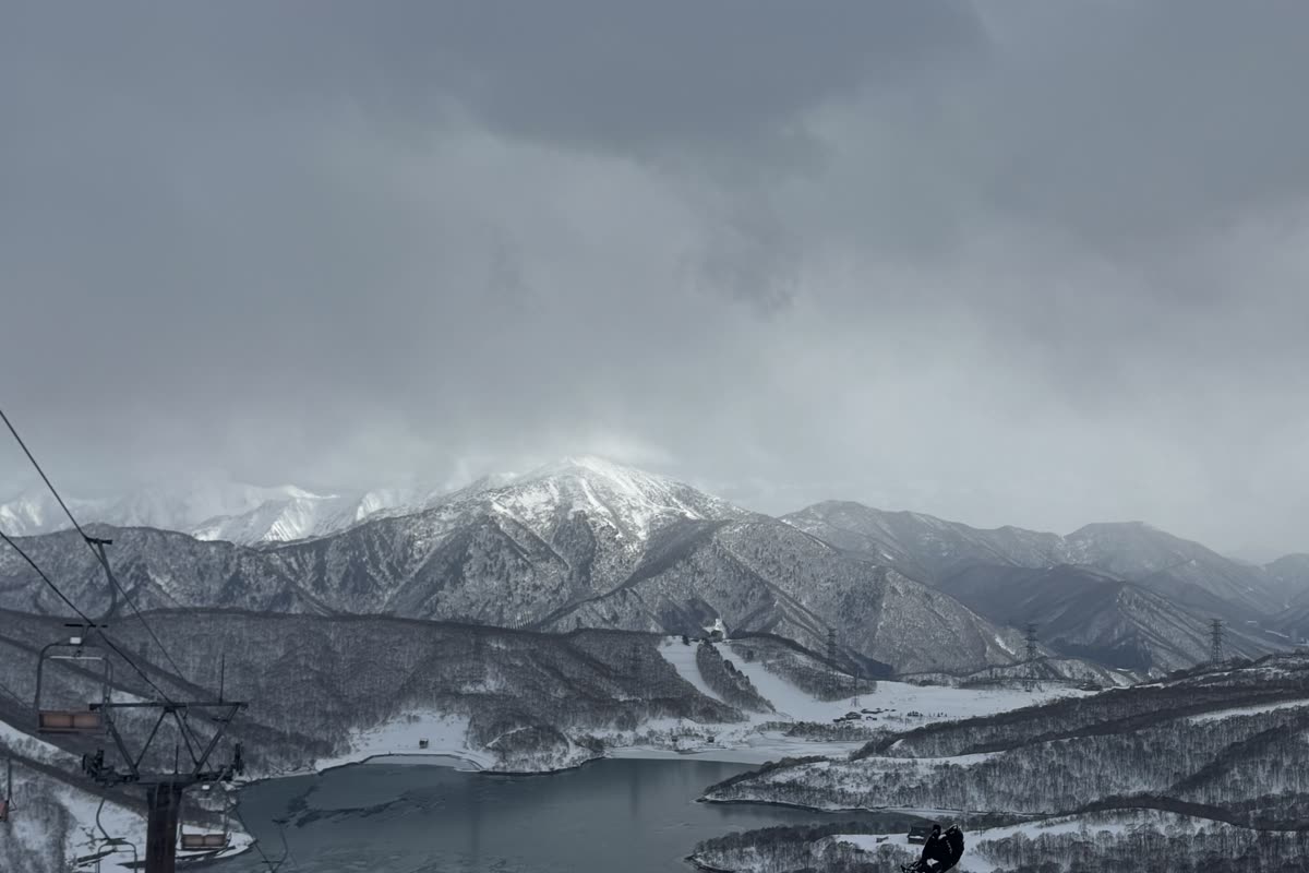 從纜車上俯瞰田代湖與遠方雪山，纜車結構入鏡
