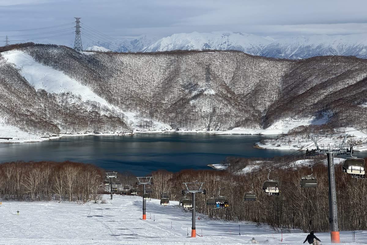 一位紅衣滑雪者站在雪道上望向雲海與遠山