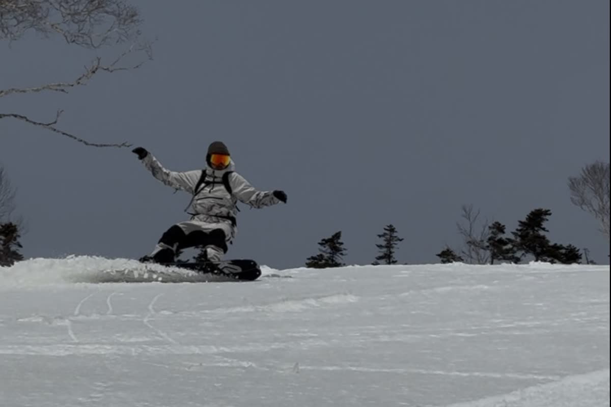 單板玩家在雲霧下的雪地上躍起